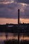 Reflection of a large industrial pipe in a quiet smooth surface of the river, in the early morning