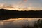 Reflection like glass of a sunset and clouds on the surface of Yates Mill pond in Raleigh, North Carolina