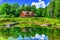 Reflection of a log cabin in the near by pond HDR