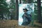 Reflection of male tourist with backpack in mirror, standing in pine forest. Hiking, trekking, staycation, active outdoor