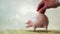 Reflection of a man putting coins into a piggy bank