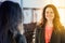 Reflection in mirror of brunette woman smiling at camera