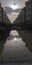 Reflection of modern buildings over stagnant rain water over under construction road.