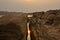 Reflection of morning sun and the river in the broken stone cliff