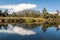 reflection of Mount Te Kinga and ancient podocarp trees in Lake Brunner (Moana) on West Coast, New Zealand