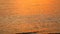 Reflection orange gold yellow light of sunset on sea surface