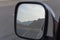 Reflection in rear view side mirror of road while driving along Jebal Jais Mountain road in Ras al Khaimah, United Arab Emirates
