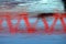 The reflection of the red railway bridge over the Mures river in Arad city.