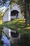 A reflection of Ritner Creek Covered Bridge in a pool of rainwater.