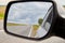 The reflection of road in the side view mirror in autumn day. Travel concept