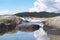 Reflection of rocks and sky on water.