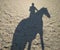 Reflection on the sand a man riding a horse silhouette rider