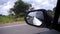Reflection side rear view car mirror on road