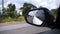 Reflection side rear view car mirror on road