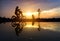 Reflection Silhouette of mother with her toddler on bicycle against the sunset and lens flare.