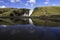 The reflection of the Skogafoss waterfall in the south of Iceland at the cliffs of the former coastline