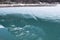 Reflection of snowy panorama of Alps in KlÃ¶ntalersee lake still partly covered with ice