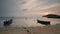 Reflection sunset boat sitting at shoreline during low tide.