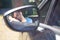 Reflection of teenage boy in wing mirror sleeping in car