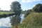 A reflection of a tree in the River Parrett in Langport, Somerset as it flows through the public park