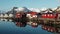 Reflection in the water. Snowy mountains, fishing village, red rorbu houses, and their peaceful reflections on the water