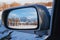 reflection of winter landscape with Tien Shan mountains and trees in field in snow in rearview mirror of car. Concept of