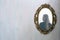 The reflection of a woman in a antique golden mirror in the vintage interior, old pattern wallpaper background