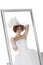 Reflection of young bride in mirror over white background