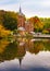 Reflections of autumn trees across Minnewater in Bruges