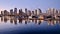 Reflections of city lights and boats in calm water.