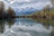 reflections of clear lake on windy day, with trees and mountains in the background