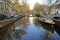 Reflections of colorful heritage buildings and a houseboat, overlooking Reguliersgracht Canal