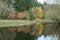 Reflections of a group of brightly coloured trees over a small l