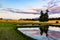 Reflections on a lake at a barley field at sunset with the backdrop of barley field and the Southern Alps Wanaka Otago New Zealand