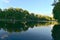 Reflections of trees and clouds on lake water, La Fontaine Park, Montreal, QC, Canada