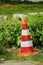 Reflective traffic cone in red, orange and white as warning from danger