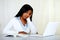 Reflective young woman studying on laptop