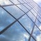 Reflexions of clouds and blue sky in facade of modern building