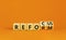 Refocus and reform symbol. Businessman turns cubes and changes the word refocus to reform. Beautiful orange table, orange