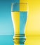 Refraction of light by a glass on a blue and yellow squared background. Abstract glass art