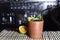 refreshing alcoholic drink with green fruits, ice vodka and gin, lemon peel served in clay glass on the counter