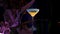 Refreshing alcoholic drink in martini glass. Stock footage. Close up of beverage served on a glass table on black