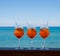 Refreshing aperitif Aperol spritz on a background of blue sea.