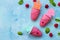 Refreshing children`s ice cream popsicles rasberry sorbet on blue concrete background. Copy space, top view flat lay background