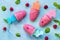 Refreshing children`s ice cream popsicles rasberry sorbet on blue concrete background. Top view flat lay background