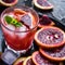 Refreshing cocktail with red blood orange, ice and mint