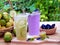 Refreshing drink with lemon lime and water lilac purple, decorated with lemon slice and purple pea flowers. Fresh lemon in the bo