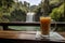 Refreshing glass of juice at picturesque riverside cafe with stunning waterfall view. Generative AI
