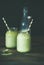 Refreshing iced coconut matcha latte drink in jars, wooden table