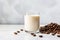 Refreshing iced coffee with milk and beans on marble table, morning drink concept